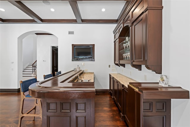 bar with coffered ceiling, sink, beamed ceiling, dark brown cabinets, and dark hardwood / wood-style flooring