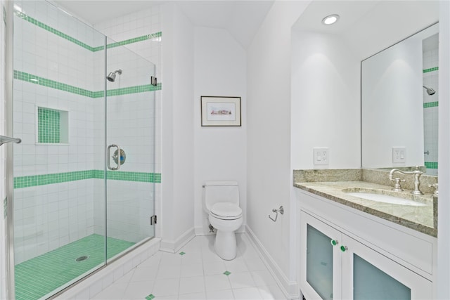 bathroom with tile patterned floors, vanity, an enclosed shower, and toilet