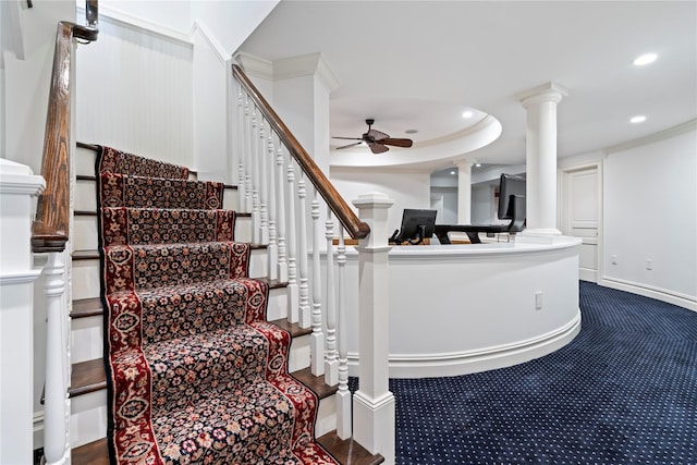 staircase with a tray ceiling and ceiling fan