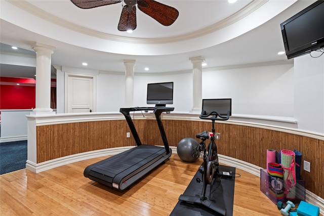 workout room featuring ceiling fan, wood-type flooring, ornamental molding, and wooden walls