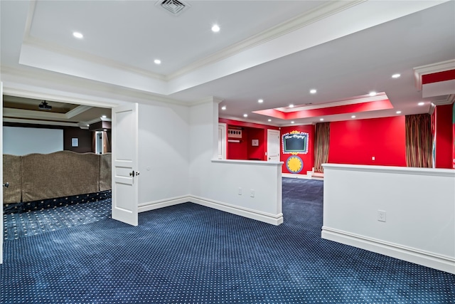 spare room featuring dark colored carpet, a raised ceiling, and ornamental molding