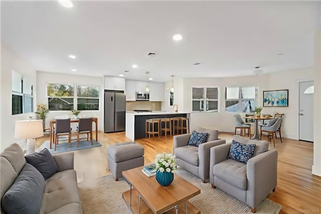 living room with a wealth of natural light and light hardwood / wood-style flooring