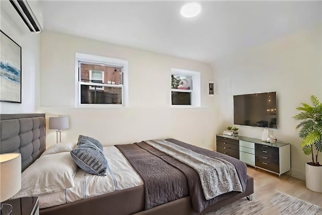 bedroom featuring a wall unit AC and light hardwood / wood-style floors