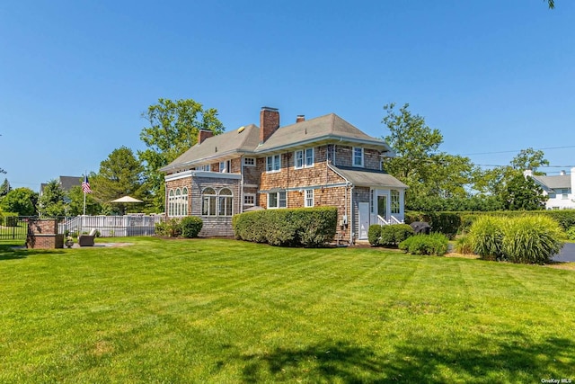 rear view of house featuring a yard