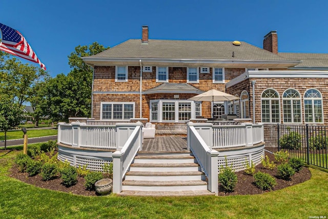 rear view of house featuring a yard and a deck