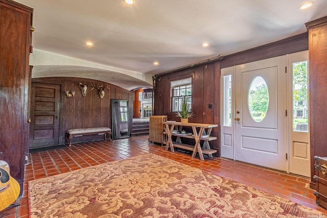 tiled foyer featuring wooden walls