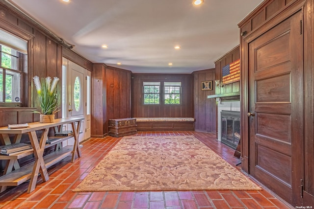 interior space with a healthy amount of sunlight, a fireplace, and wooden walls