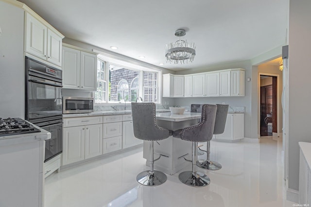 kitchen with white cabinets, light tile patterned floors, decorative light fixtures, a kitchen bar, and a chandelier