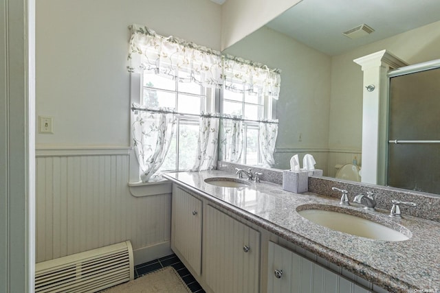 bathroom featuring tile patterned flooring, vanity, and a shower with door