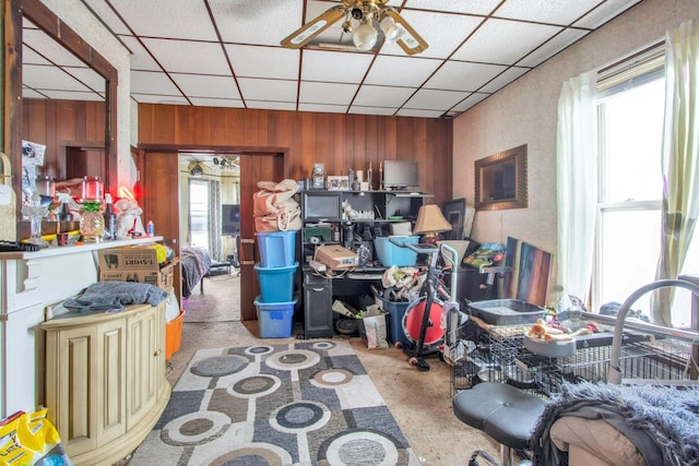 miscellaneous room with ceiling fan, a healthy amount of sunlight, light colored carpet, and wood walls