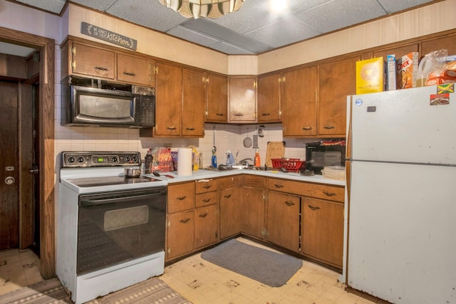 kitchen featuring white refrigerator, tasteful backsplash, and electric range