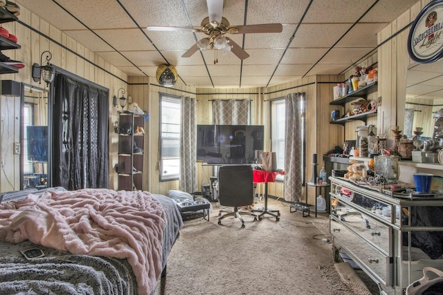 bedroom featuring carpet floors, multiple windows, wood walls, and ceiling fan