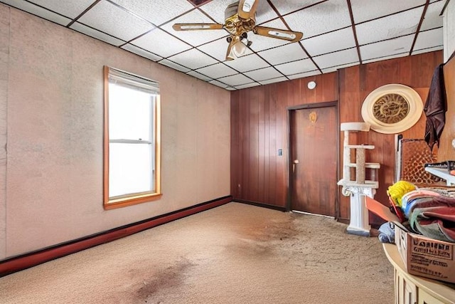 spare room featuring light carpet, ceiling fan, and a drop ceiling