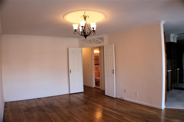 empty room with a chandelier, dark wood-type flooring, and crown molding