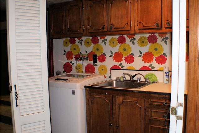 laundry area with cabinets, sink, and washer / dryer