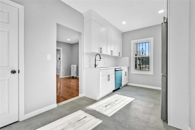 kitchen with white cabinetry, radiator heating unit, dishwasher, sink, and tile patterned flooring