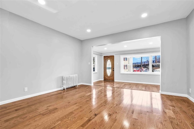 foyer with radiator and hardwood / wood-style flooring