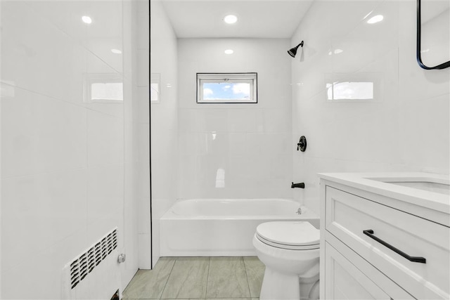 full bathroom featuring vanity, toilet, radiator heating unit, and tiled shower / bath