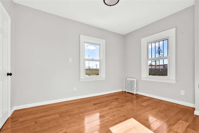 spare room with radiator and light hardwood / wood-style floors