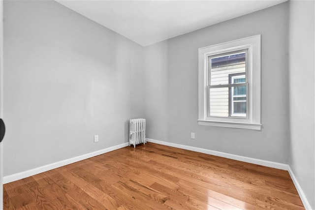 unfurnished room with light wood-type flooring and radiator