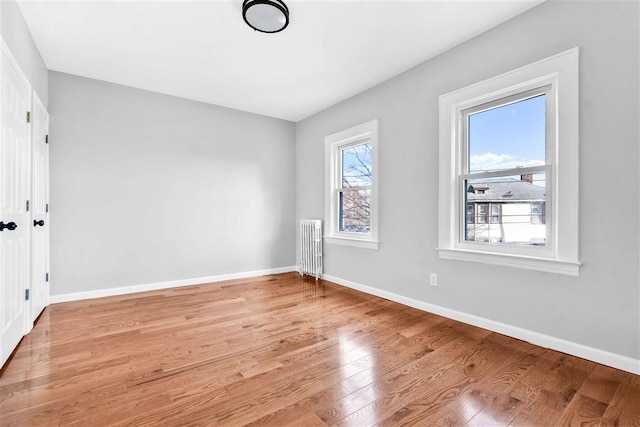 unfurnished bedroom with light hardwood / wood-style floors and radiator