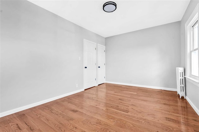 unfurnished room with radiator and light hardwood / wood-style floors