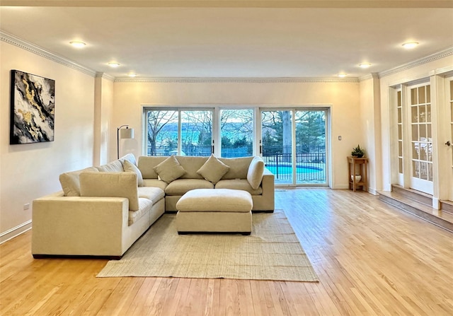 living room with plenty of natural light, ornamental molding, and light hardwood / wood-style flooring