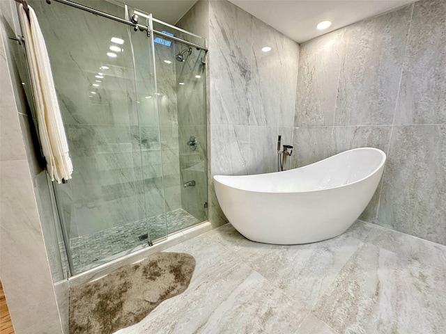 bathroom featuring tile walls and plus walk in shower