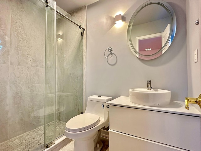 bathroom with vanity, a shower with shower door, and toilet