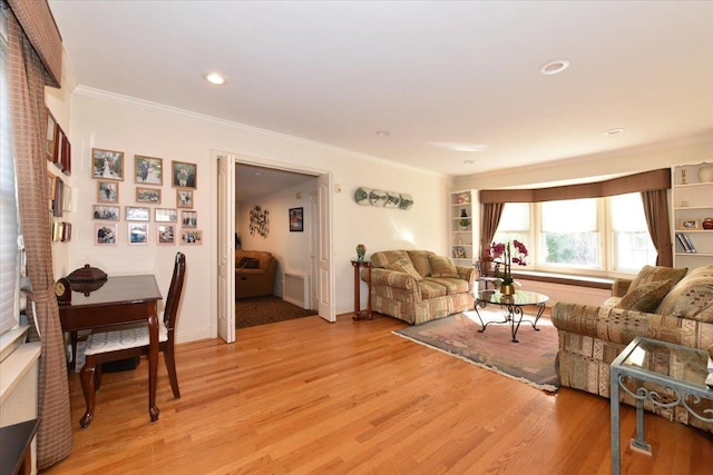 living room with light hardwood / wood-style flooring and crown molding