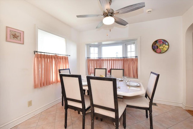 tiled dining space with ceiling fan