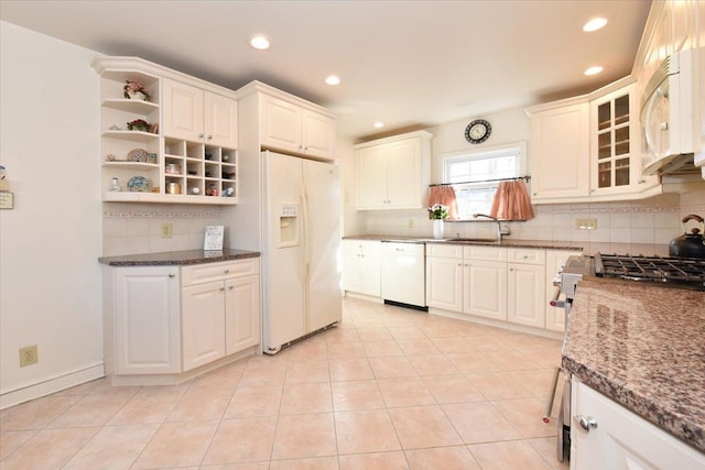 kitchen featuring dark stone counters, white appliances, and white cabinetry