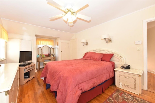 bedroom featuring ceiling fan, hardwood / wood-style floors, crown molding, and lofted ceiling