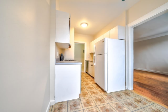 kitchen featuring white cabinetry, dishwasher, and white refrigerator