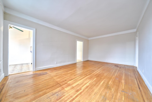 empty room with light hardwood / wood-style floors and crown molding