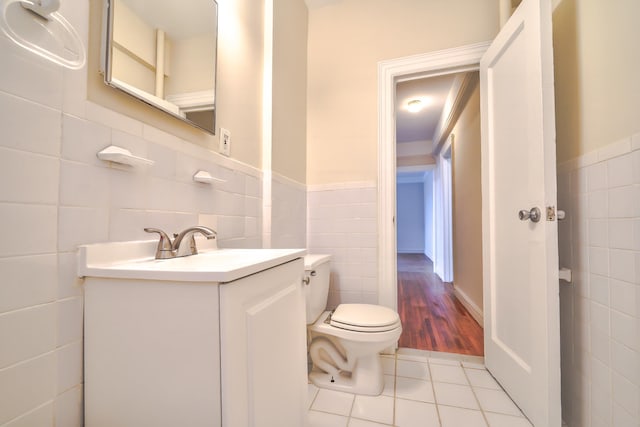 bathroom featuring tile patterned floors, vanity, tile walls, and toilet