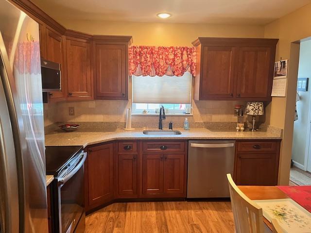 kitchen featuring sink, stainless steel appliances, and light hardwood / wood-style flooring