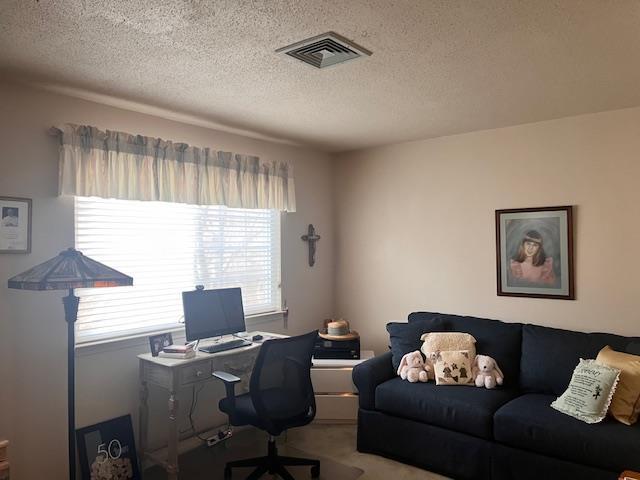 carpeted home office with a textured ceiling