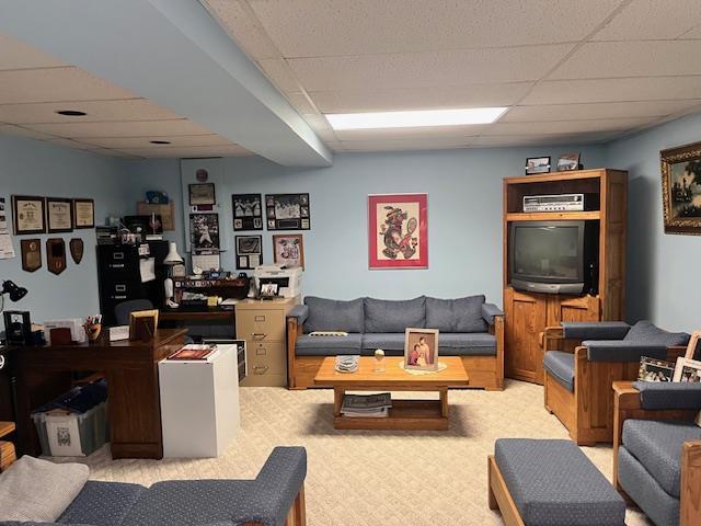 carpeted living room featuring a paneled ceiling