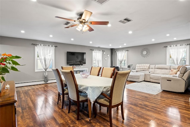 dining space featuring a baseboard heating unit, dark hardwood / wood-style floors, and plenty of natural light