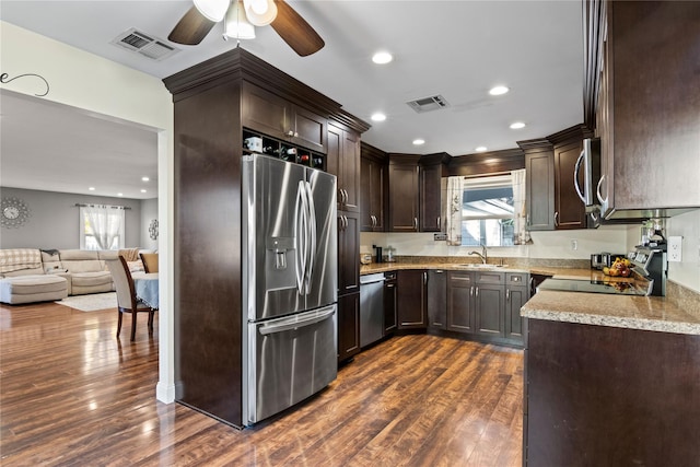 kitchen featuring sink, dark wood-type flooring, appliances with stainless steel finishes, and dark brown cabinets