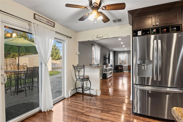 kitchen featuring stainless steel fridge with ice dispenser, ceiling fan, dark hardwood / wood-style floors, baseboard heating, and dark brown cabinetry