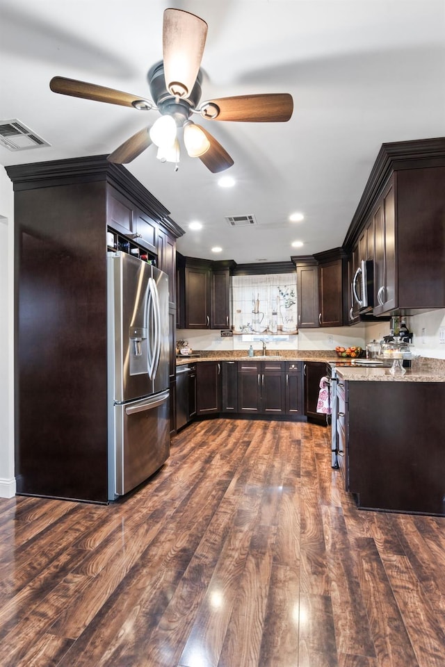 kitchen featuring light stone countertops, appliances with stainless steel finishes, dark hardwood / wood-style flooring, sink, and dark brown cabinets