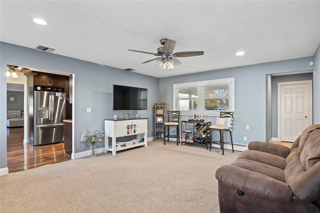 carpeted living room featuring ceiling fan and a baseboard radiator