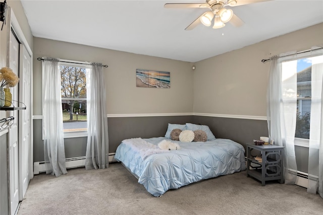 carpeted bedroom featuring ceiling fan, baseboard heating, and a closet