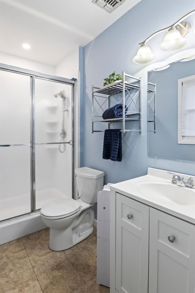 bathroom with toilet, tile patterned flooring, walk in shower, and vanity