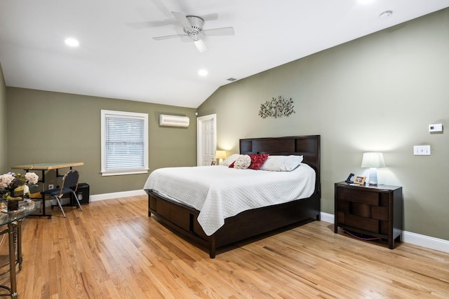 bedroom featuring ceiling fan, lofted ceiling, light hardwood / wood-style floors, and a wall mounted air conditioner