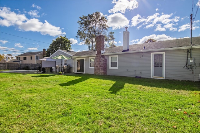 rear view of property featuring a gazebo and a yard