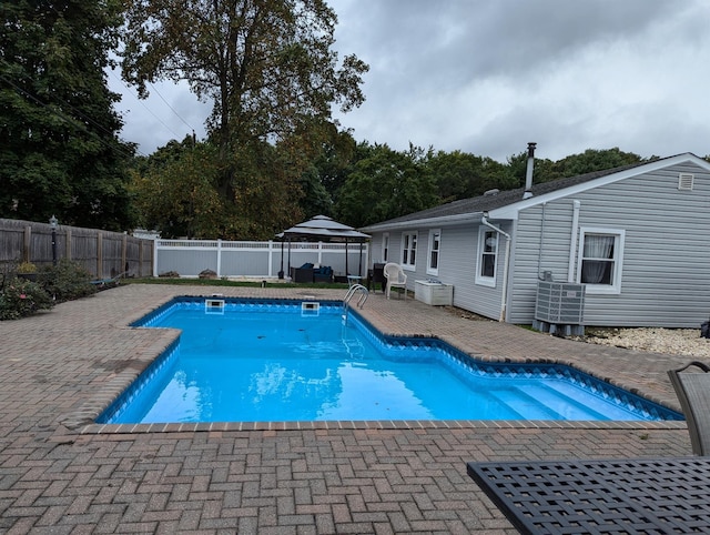 view of swimming pool with a patio area, a gazebo, and central AC unit