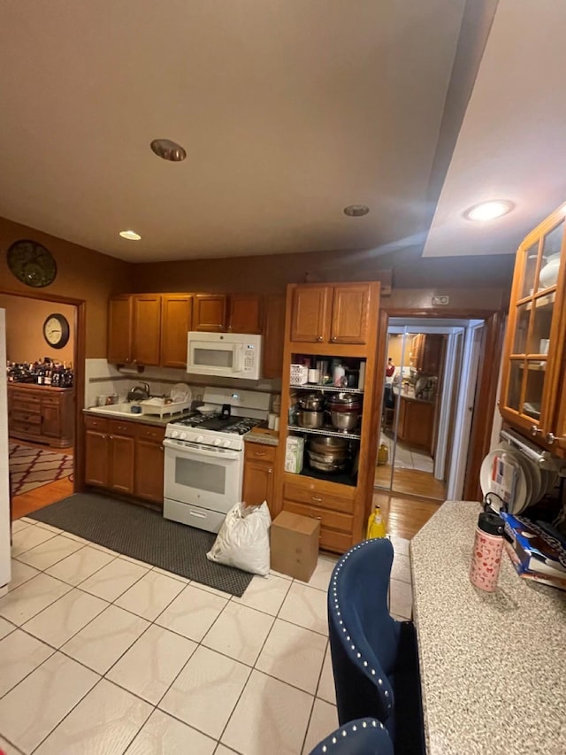 kitchen featuring light tile patterned floors and white appliances